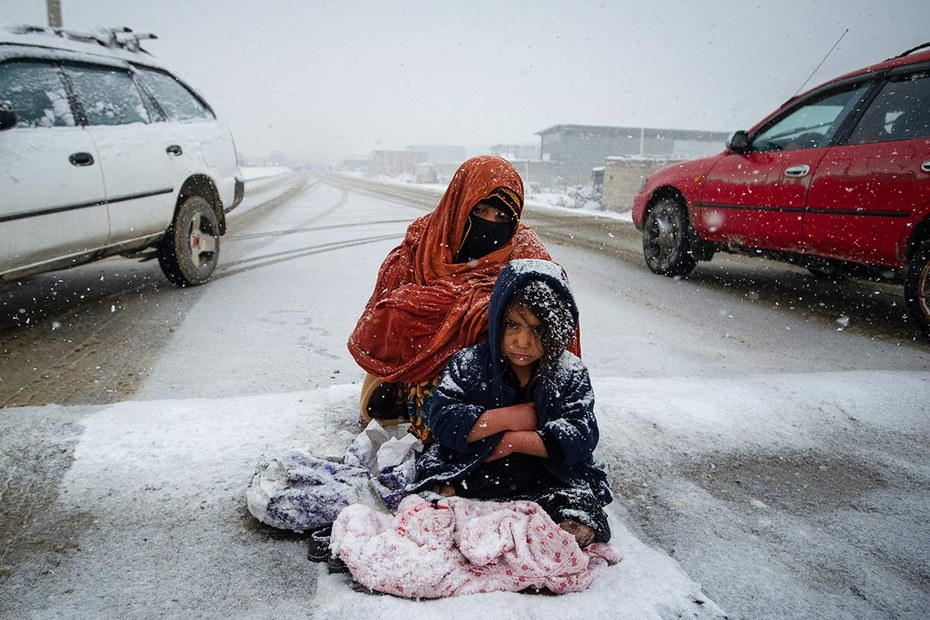 Mutter und Tochter betteln auf einer Straße