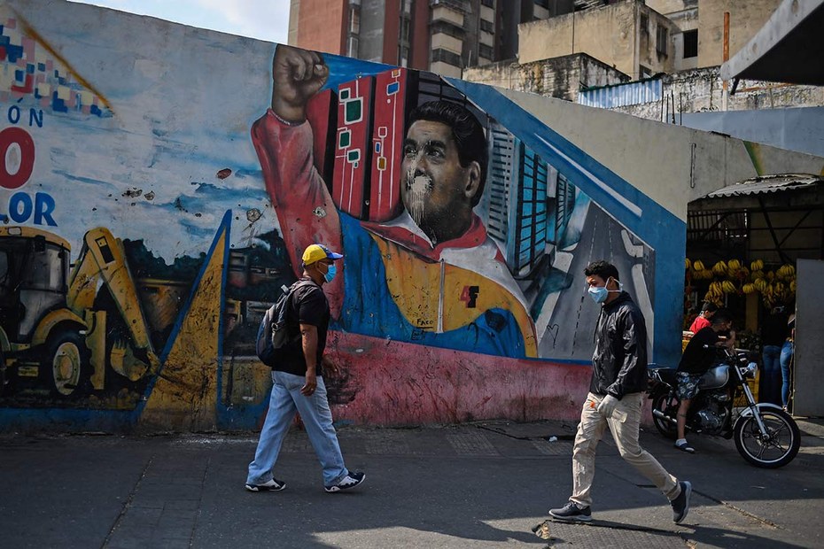 Szene in der venezolanischen Hauptstadt Caracas. Im Hintergrund ist ein Graffito, das Präsident Nicolás Maduro abbildet