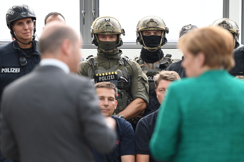 Einsatzbesprechung während des Gipfels mit Olaf Scholz (links) und Angela Merkel