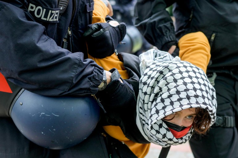 Eine Studentin wird bei dem Protestcamp an der Freien Universität Berlin von der Polizei weggetragen