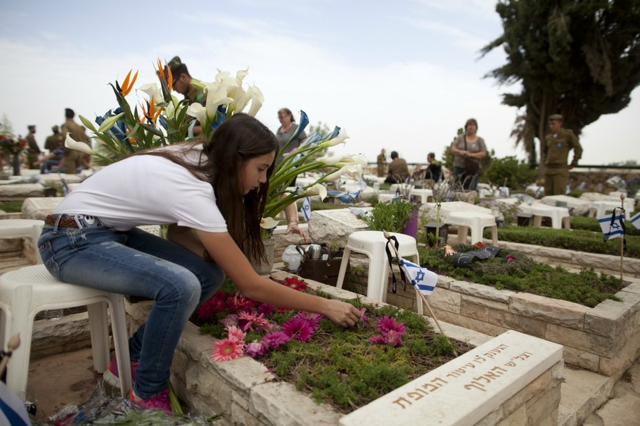 Eine Israelin legt an Jom haSikaron Blumen an einem Grab nieder