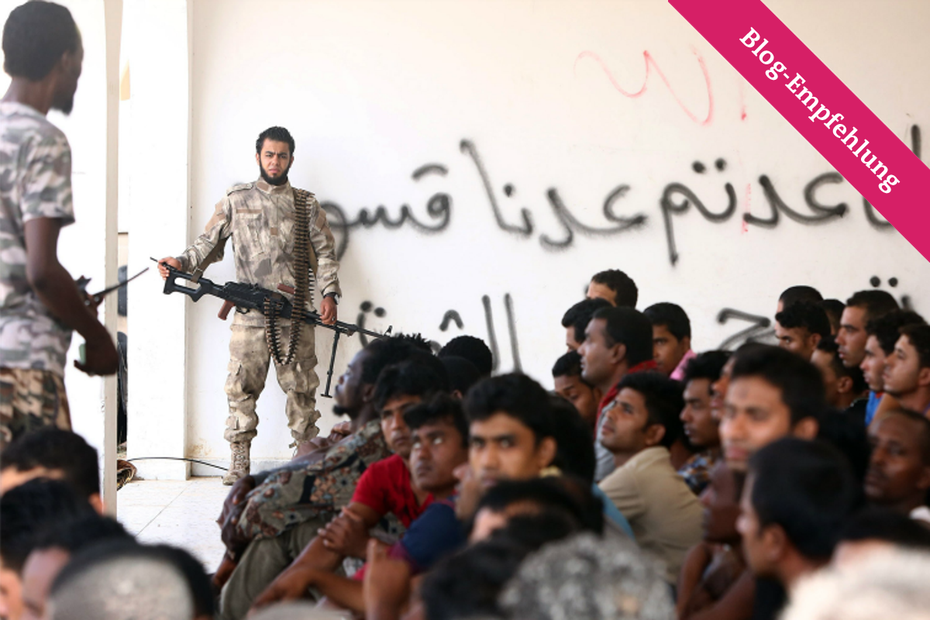 Flüchtend werden in einer Unterkunft nahe der Stadt Zuwara bewacht, nachdem sie von der libyschen Küstenwache aufgegriffen wurden