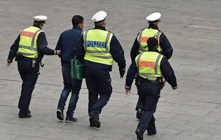 Polizisten am Kölner Hauptbahnhof führen einen Mann ab
