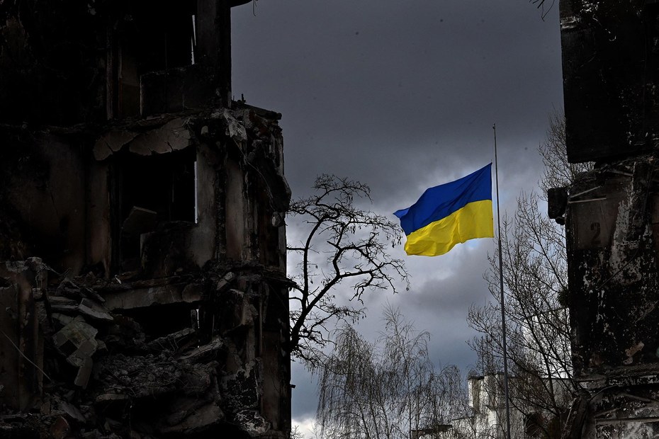 Die ukrainische Flagge zwischen zerstörten Häuserfronten in Borodjanka