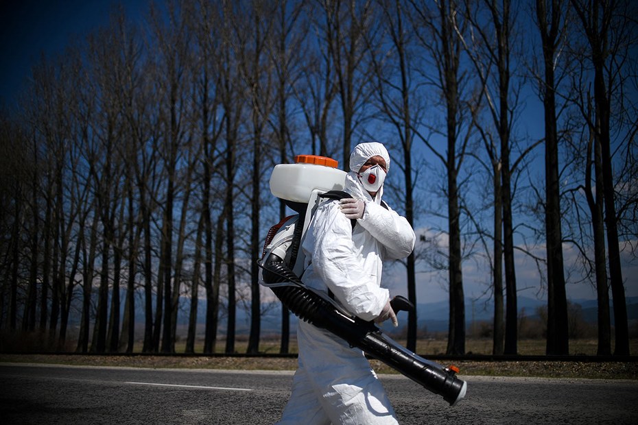 Ein Arbeiter im Schutzanzug desinfiziert Autos in einem bulgarischen Skiort