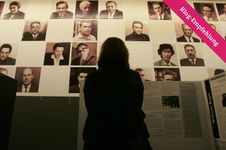Eine Besucherin im Martin-Gropius-Bau betrachtet Fotos der Zeugen in den Auschwitzprozessen