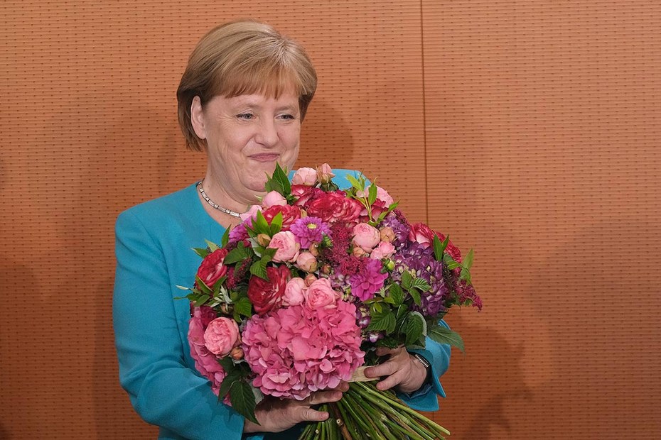 Angela Merkel empfängt einen Strauß von Bundesjustizministerin Christine Lambrecht zu ihrem 65. Geburtstag. Herzlichen Glückwunsch.