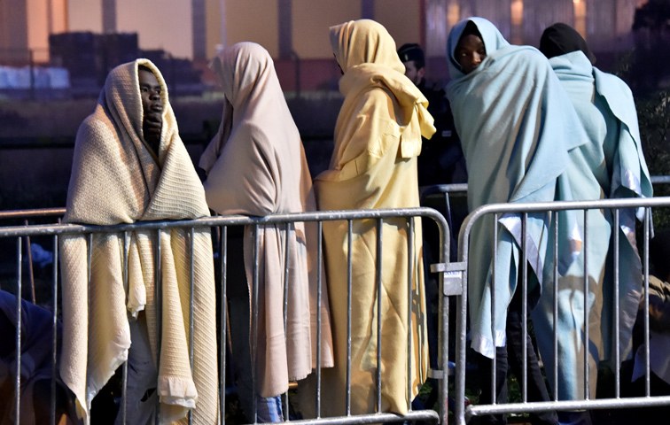Flüchtende warten in Calais auf den Transport in Registrierungszentren
