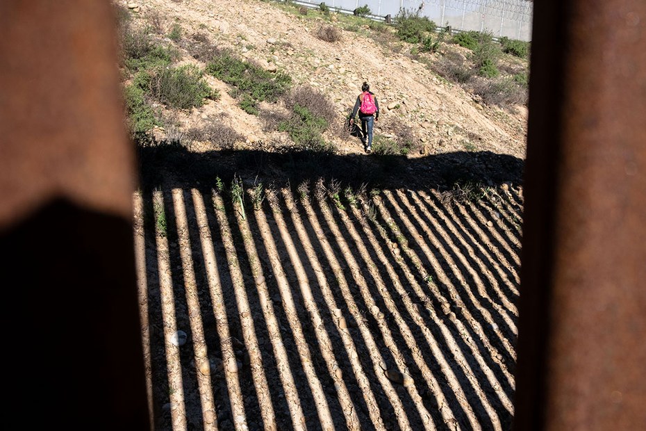 Eine junge Frau bei dem Versuch die Grenze bei Tijuana, Mexiko, zu überqueren