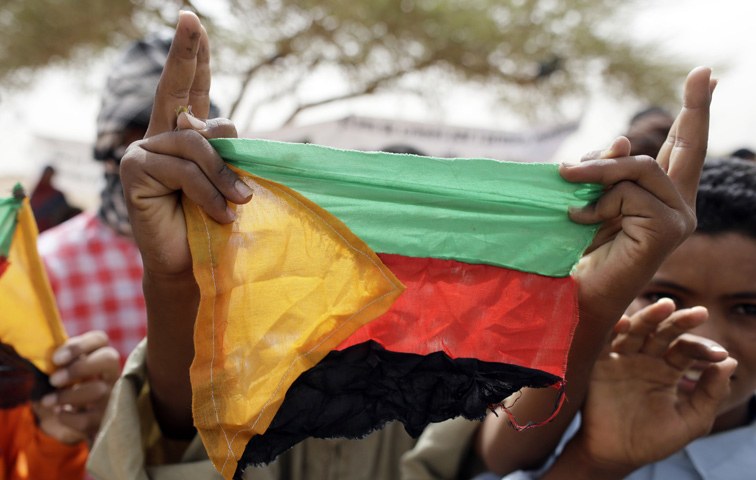 Ein Tuareg hält die Flagge der MNLA in die Luft, der politischen und militärischen Organisation im malischen Azawad