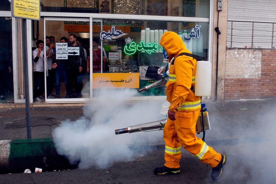Ein iranischer Feuerwehrmann desinfiziert die Straßen von Teheran