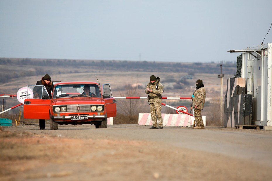 Eine Frau steigt in ein Auto an einem der neuen Checkpoints in der Ostukraine, nahe der Stadt Zolote
