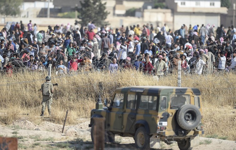 Türkischen Grenzposten blockieren syrische Flüchtlinge, die aus den bombardierten Zonen kommen