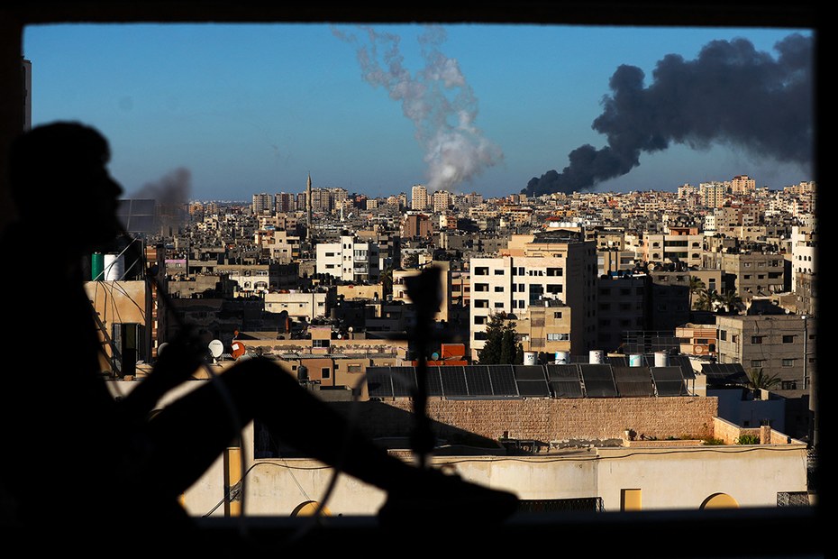 Palästinensische Normalität: Ein Mann raucht Wasserpfeife, im Hintergrund schlagen die Raketen in Gaza ein