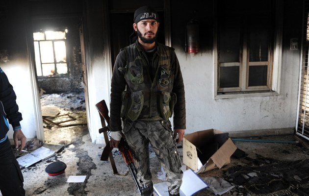 Ein syrischer Oppostitionskämpfer in einem zerstörten Haus in Ras al-Ain