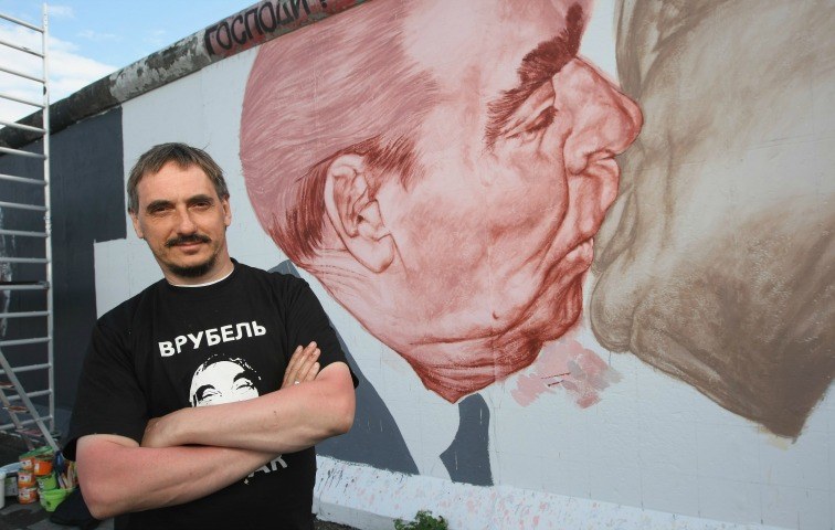 Dmitri Vrubel bei der Restauration seines Wandgemäldes, dem Bruderkuss, an der Berliner Mauer 2009