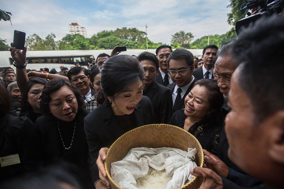 So ein schöner Reis aber auch! Premierministerin Yingluck Shinawatra (M.) beglückt er hier noch, später zwingt er sie zur Flucht