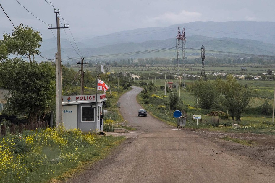 Ein georgischer Grenzsoldat reicht Essen zu einem Bauer, der auf dem Territorium des von Russland kontrollierten Südossetiens steht