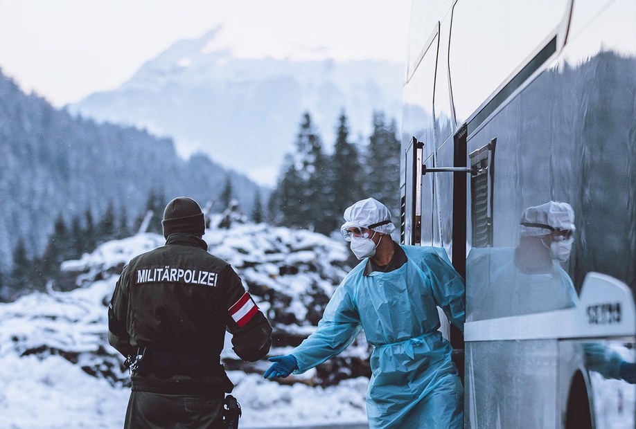 Unterwegs in Österreich: Ein Mitarbeiter des Testteams gibt einem Militärpolizisten einen Testbefund, mit dem man ausreisen darf