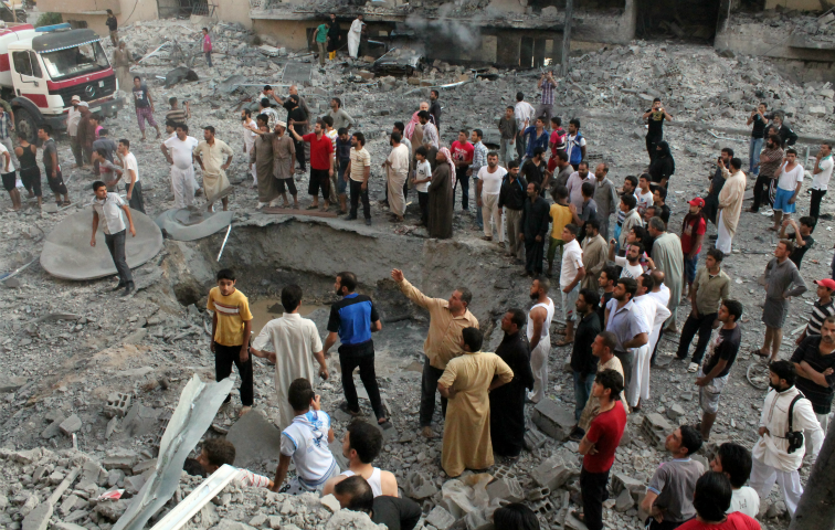 Menschen versammeln sich 2013 in der syrischen IS-Hochburg Raqqa um einen Bombenkrater