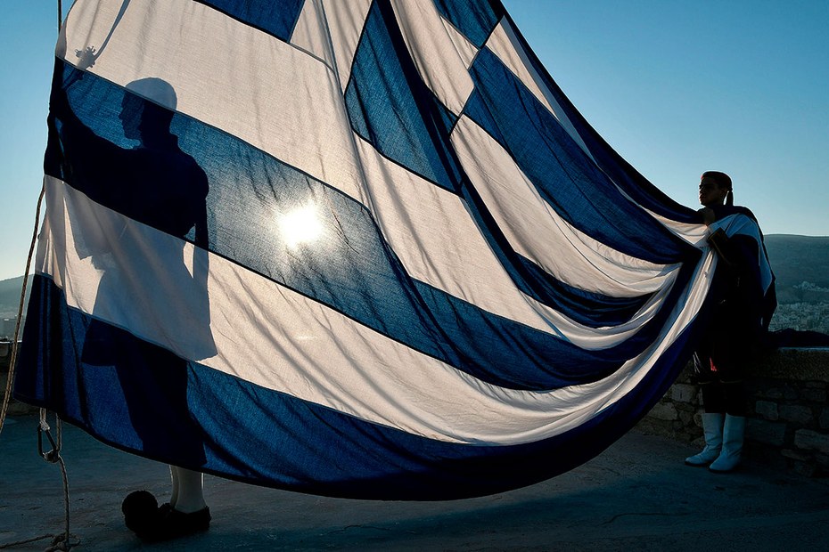 Die sogenannten Evzonen, die Leibgarde des Präsidenten, halten die griechische Flagge