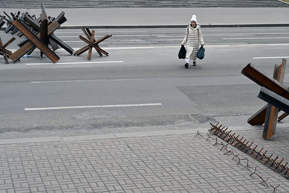Eine Anwohnerin überquert im Zentrum von Kiew eine zum Teil verbarrikadierte Straße.