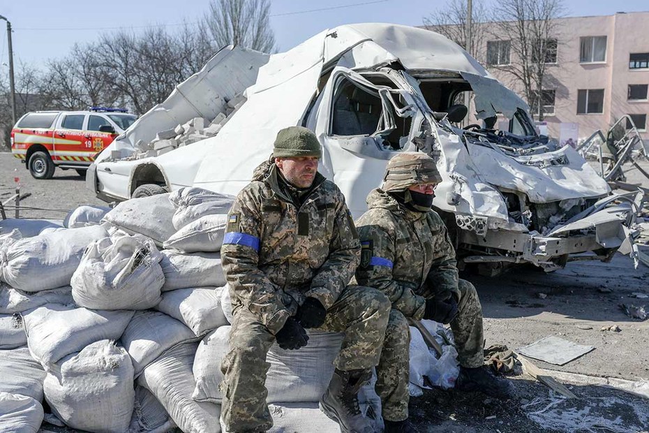 Ukrainische Soldaten neben einer zerstörten Militärschule in Mykolajiw, Südukraine