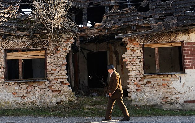 Ein Mann läuft im kroatischen Dvor an den Ruinen des Krieges von 1991-1995 vorbei