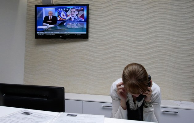Während im Hotel "Air Express" des Moskauer Flughafens Edward Snowden über den Bildschirm flimmert, geht eine Rezeptionistin ihrer Arbeit nach