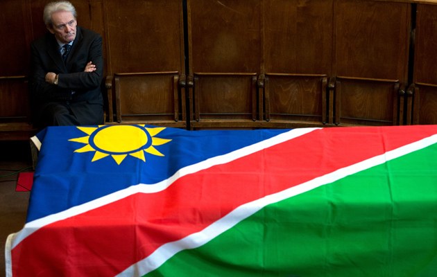 Der Vorstandsvorsitzende der Charité Karl Max EInhäupl neben den mit der namibischen Fahne verdeckten Gebeinen