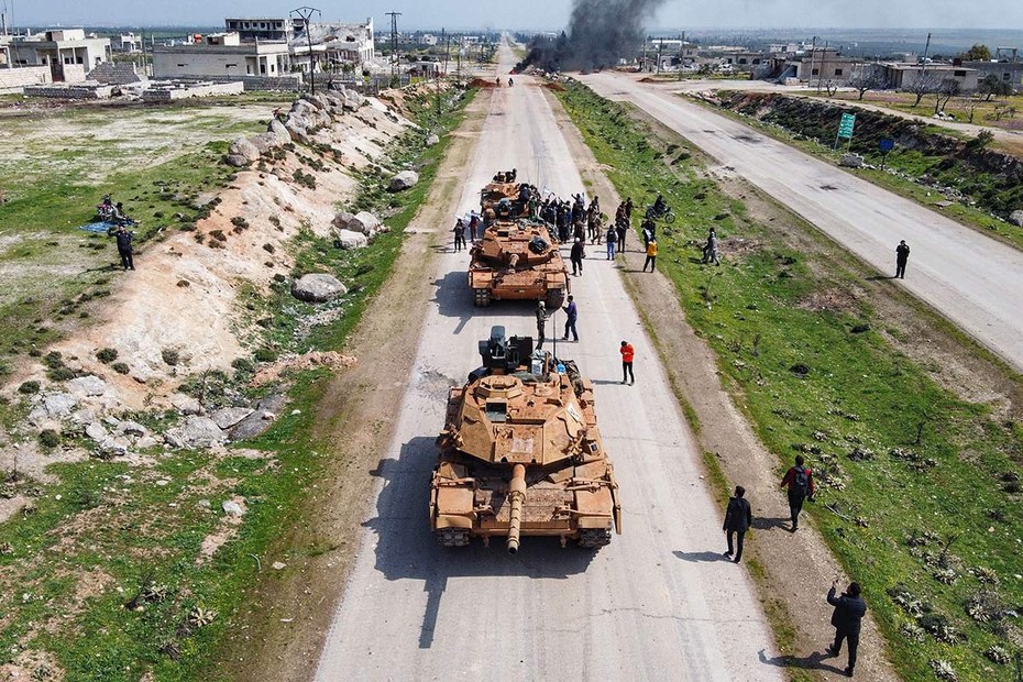 Protestierende stoppen einen Panzer auf der Autobahn M4, die Aleppo und Latakia verbindet