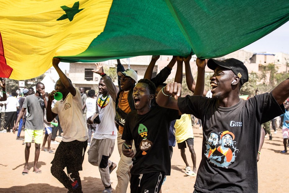 Männer schwenken die senegalesische Flagge: Wie es in Senegal politisch weitergehen wird, ist ungewiss