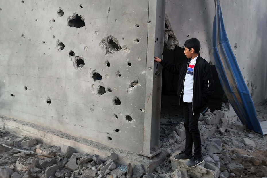 Ein libyscher Junge neben einem durch einen Luftangriff zerstörten Gebäude in Tripolis