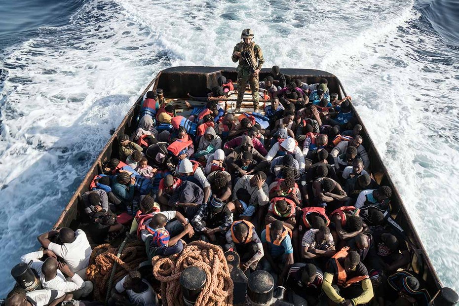Mittelmeer, 45 Kilometer westlich von Tripolis: Geflüchtete, Angehöriger der libyschen Küstenwache