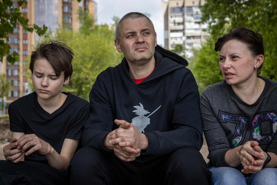 Die Familie Tschechonatski: Artem, Jegor und Olena sitzen am Ufer des Flusses Dnipro in Saporischschja. Sie gehörten zu der letzten Gruppe von Zivilisten, die offiziell aus Asowstal evakuiert wurden.