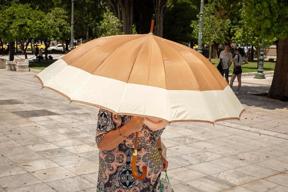 Eine Frau in Athen schützt sich mit einem Sonnenschirm vor der Sonne. Griechenland geht in die dritte Hitzewelle des Jahres