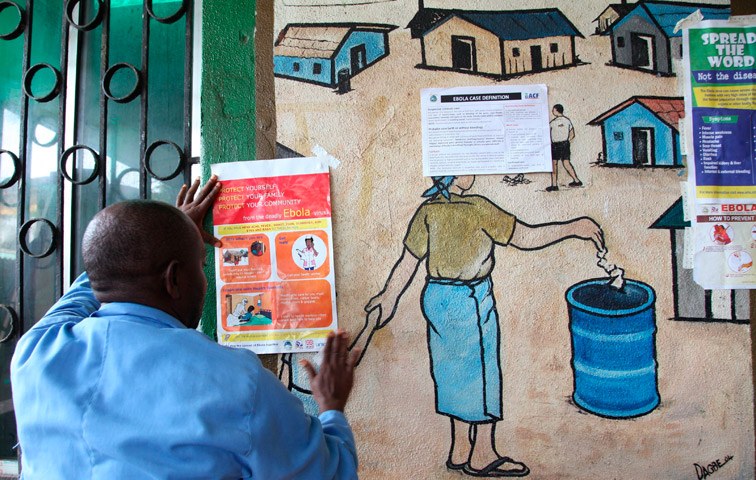 Ein Krankenpfleger befestigt Ende Juli ein Warnschild zur Ebola in einem Gesundheitszentrum in Monrovia