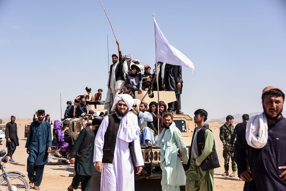 Taliban-Kämpfer und Anwohner auf einem Panzerfahrzeug der afghanischen Armee, während der dreitägigen Waffenruhe im Juni