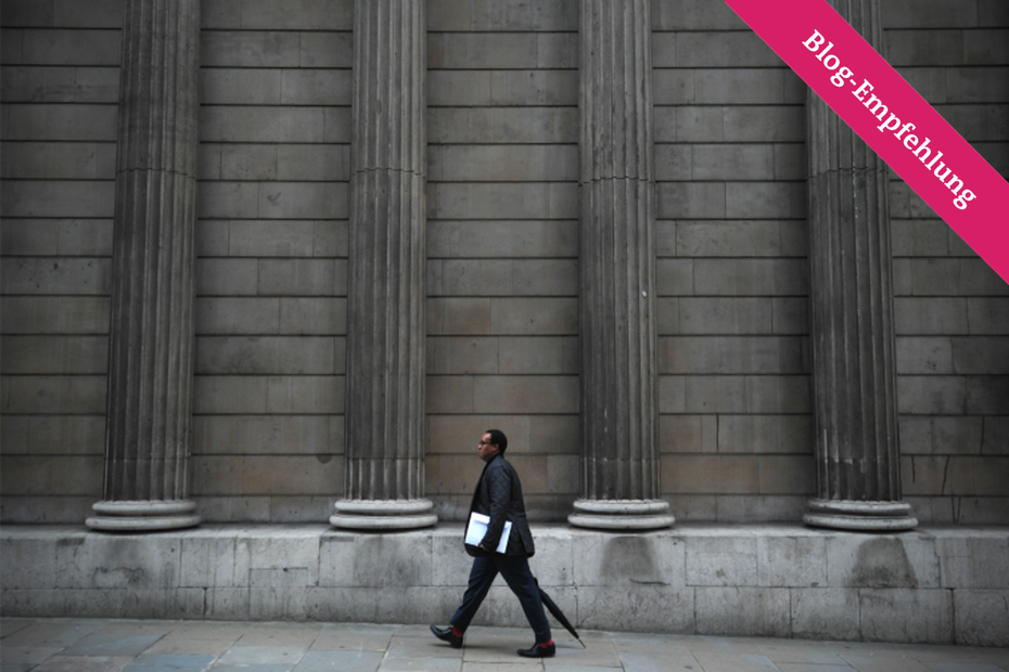 Ein Mann läuft an der Fassade der Bank of England entlang, welche 1694 gegründet und eine der ersten Zentralbanken wurde