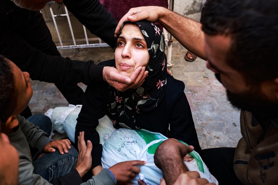 Menschen versuchen einer Frau Trost zu spenden, die ihre bei einem israelischen Luftschlag getötete Tochter in Händen hält. Rafah im Süden des Gazastreifens, 1. Dezember 2023.