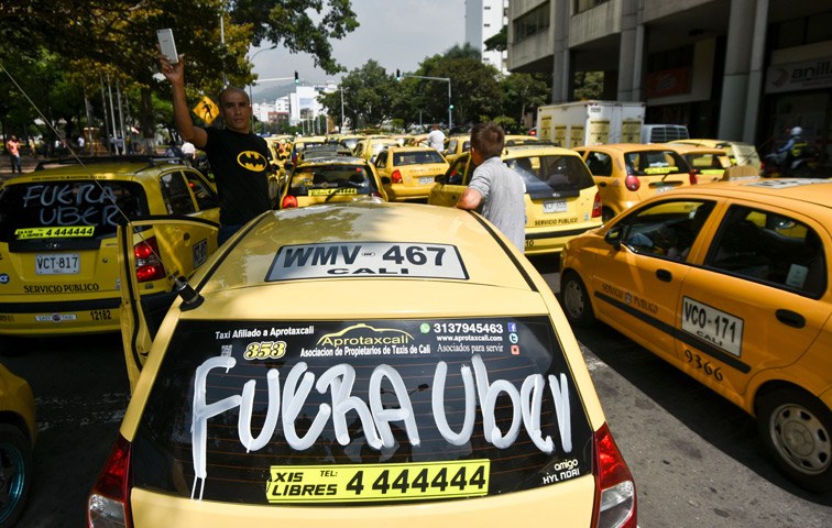 „Uber raus“ steht auf der Heckscheibe eines Taxis im kolumbianischen Cali
