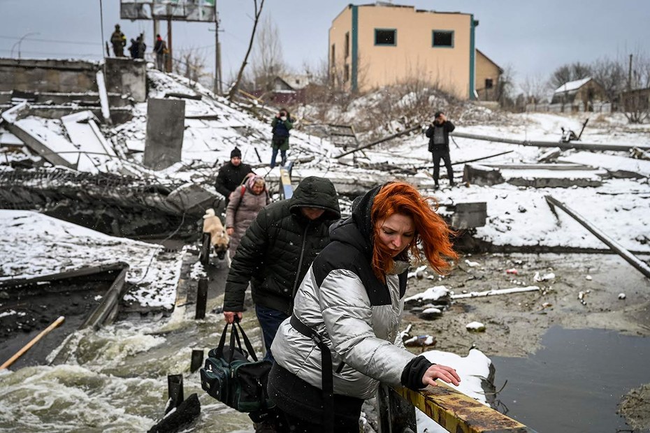 März 2022: Zivilisten passieren einen Fluss nahe Kiew. Die dazugehörige Brücke wurde gesprengt