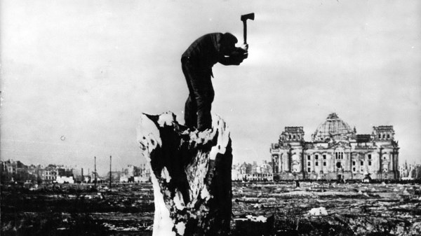 Ein Mann auf der Suche nach brennbarem Holz vor dem zerstörten Reichstag, 1945 Das Jahr der Wiedergeburt der Demokratie