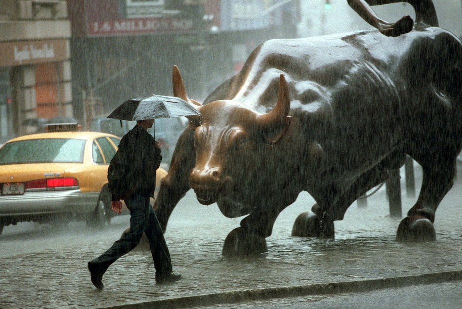 Ein Fußgänger läuft auf der Wall Street von New York City durch den strömenden Regen.
