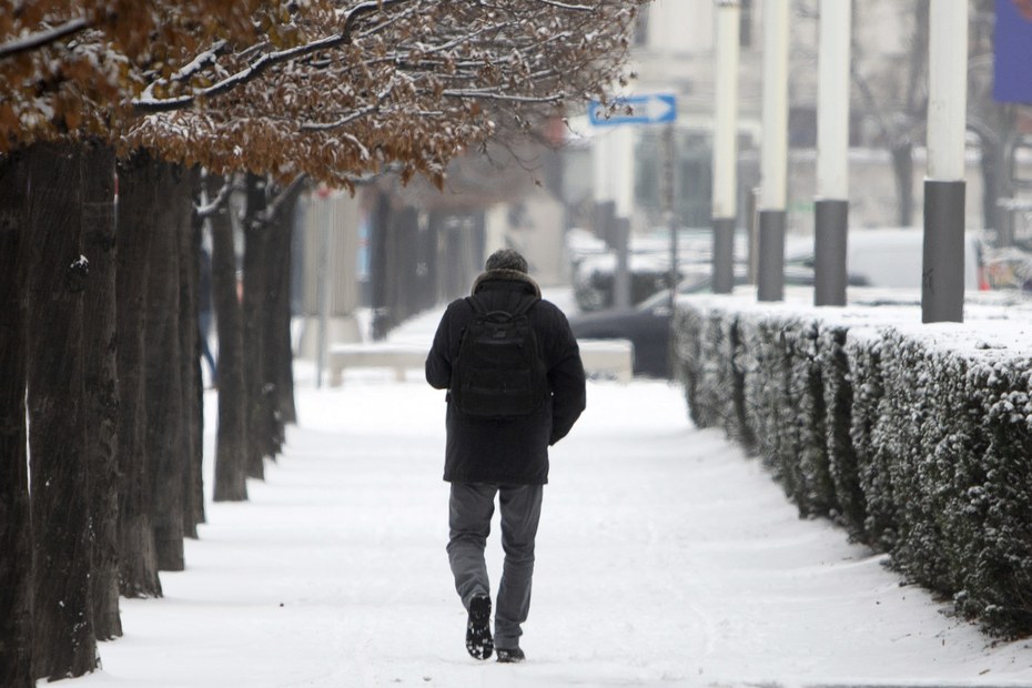 Ein Mann läuft durch die verschneiten Straßen von Österreichs Hauptstadt Wien.