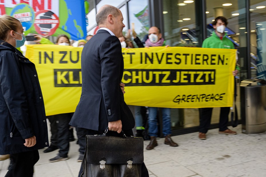 Olaf Scholz passiert einige Greenpeace-Demonstant*innen auf dem Weg zur voraussichtlich letzten Runde der Sondierungsgespräche mit den Grünen und der FDP.