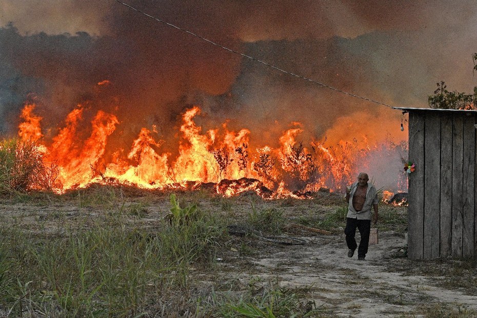 Ein Bauer, der, als sich Flammen seinem Haus in einem Gebiet des Amazonas-Regenwaldes südlich von Novo Progresso nähert, sein Grundstück verlässt.