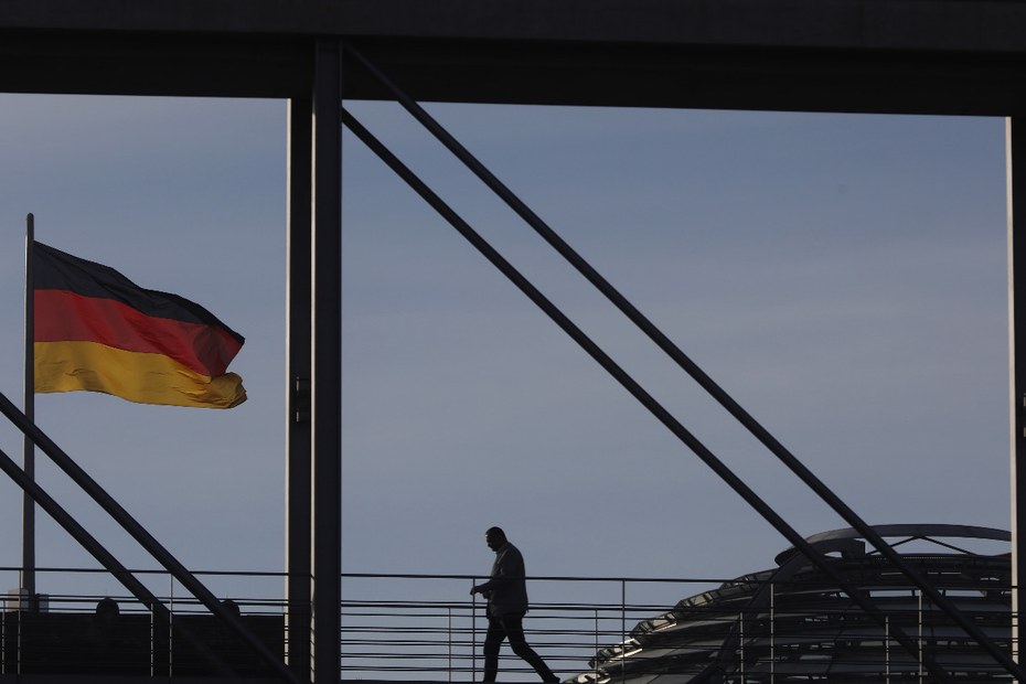 Ein Abgeordneter auf dem Weg zu einer Sitzung, im Hintergrund der Berliner Reichstag