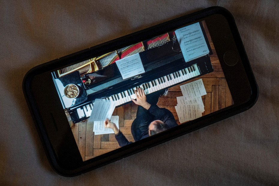 Ein Handy zeigt eines der unzähligen „Hauskonzerte“, die der Pianist Igor Levit während des ersten Lockdowns von zuhause aus für seine Zuhörer*innen streamte