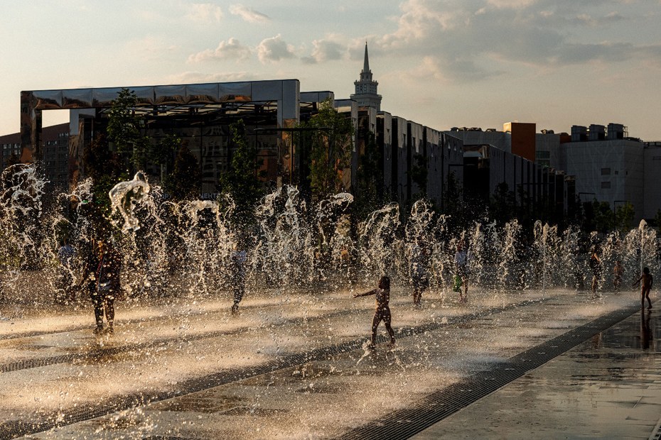 Kinder spielen in einem Springbrunnen während eines heißen Sommertags in Moskau.
